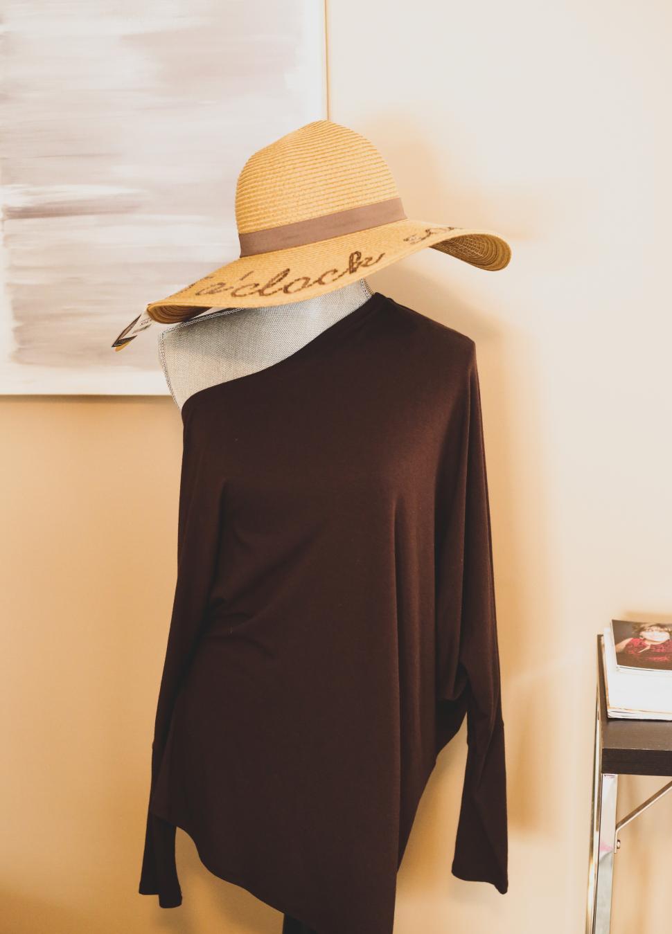 Free Image of Chic outfit with a big sun hat indoors 