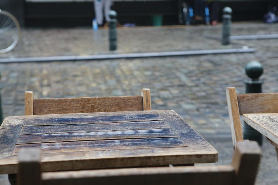 Free Image of Wooden tables on a cobblestone street in a quiet area 
