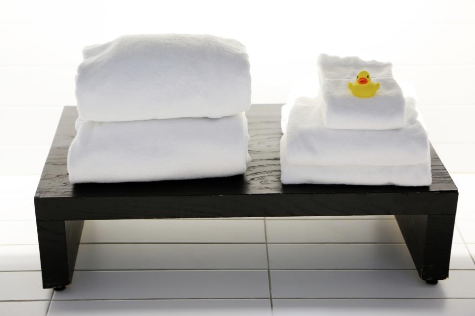 Free Image of White towels on a black rack with a rubber duck 