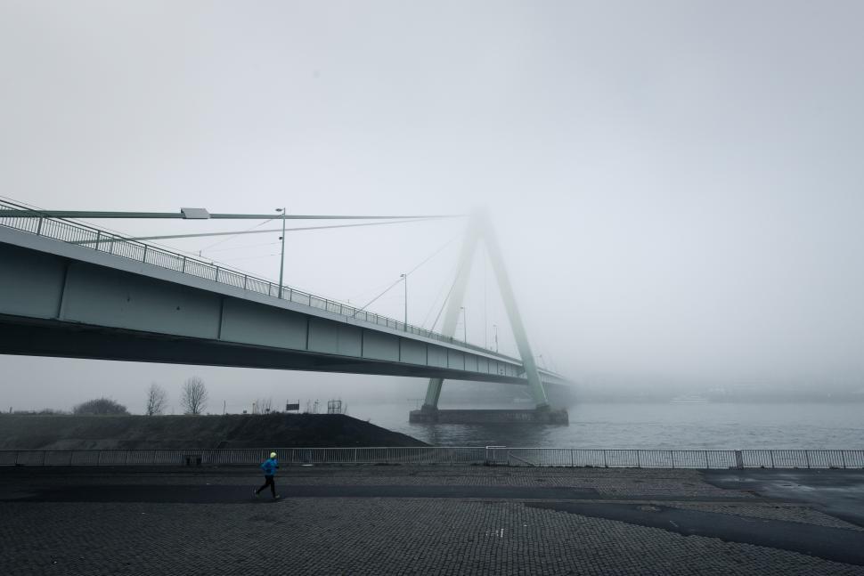 Free Image of Foggy morning walk near a bridge over the river 