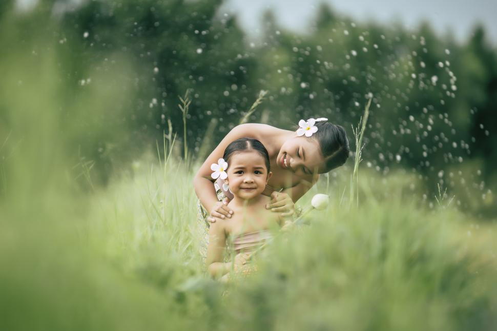 Free Image of Lovely sister and young sister sitting in meadow 