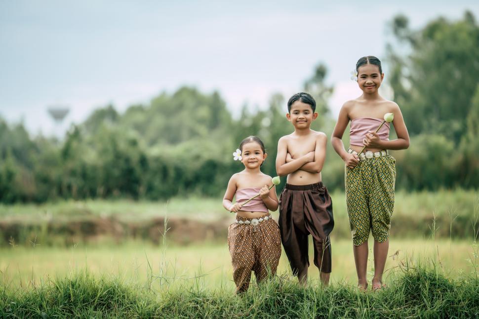Free Image of Siam kids in Thai traditional dress standing in rice field 