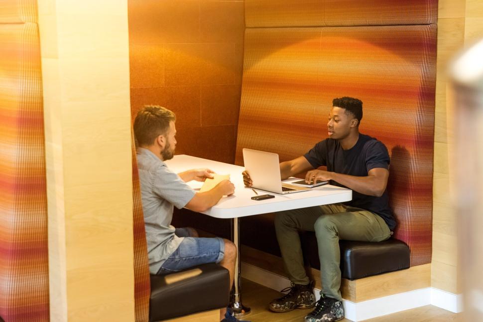 Free Image of Two men engage in discussion at a cozy table 