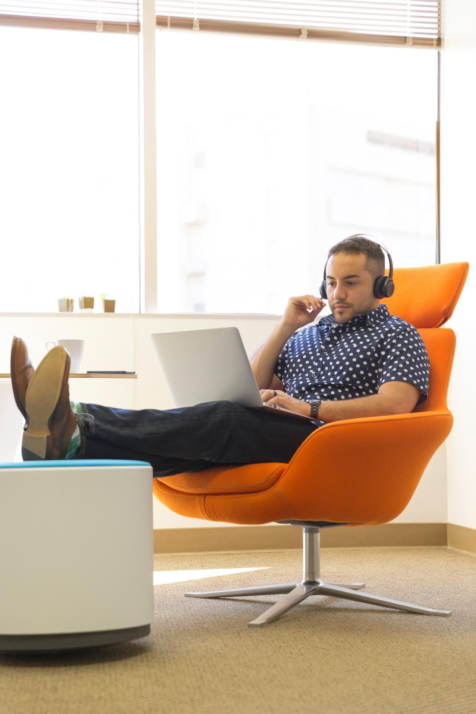 Free Image of Man working on laptop in modern office with headset 
