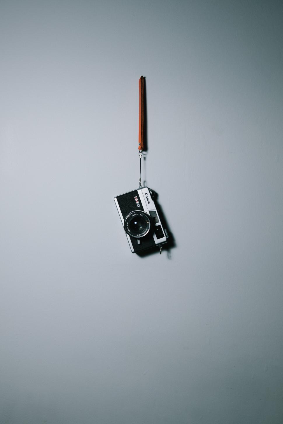 Free Image of Old camera hanging on a wall in intriguing display 