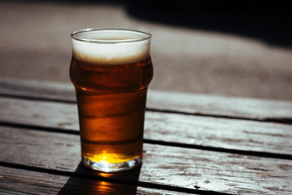 Free Image of Craft beer served in a glass during sunny outdoor gathering 
