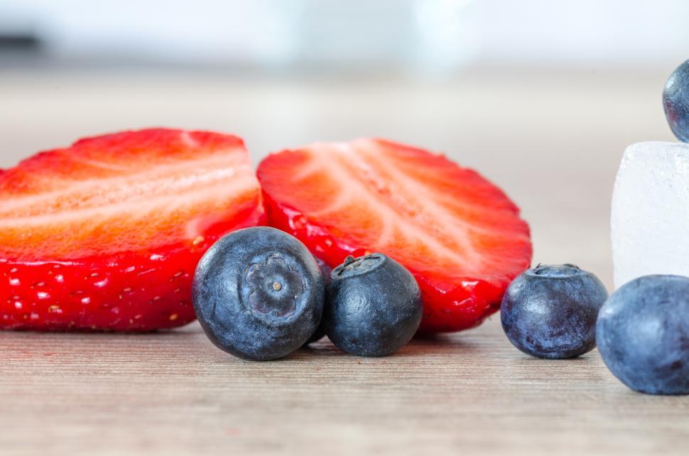 Free Image of Fresh strawberries and blueberries arranged on wooden table 