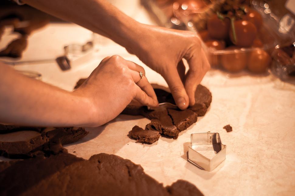 Free Image of Creating gingerbread cookies with hands and cutters 
