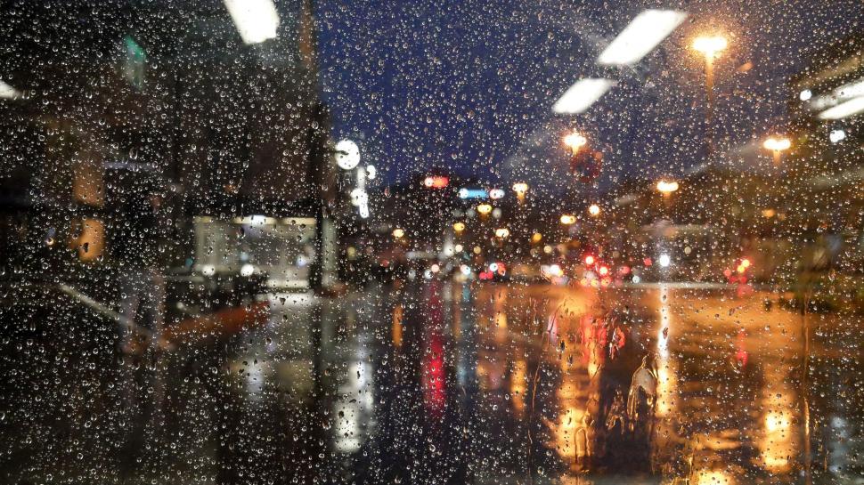 Free Image of Raindrops on window during urban nighttime 