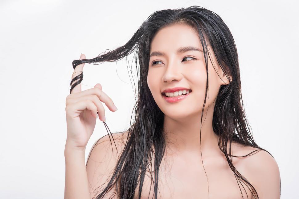 Free Image of A beautiful, beautiful woman catches her messy hair. 