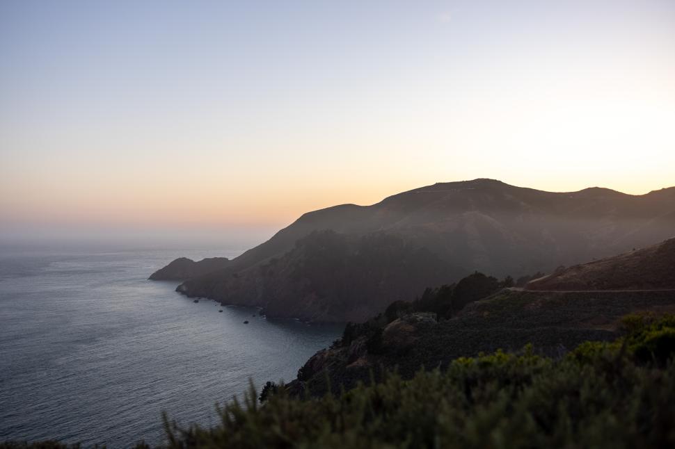 Free Image of Scenic coastal view at sunset with soft colors in the sky 