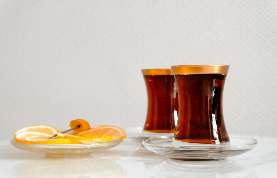 Free Image of Tea in traditional pear-shaped glasses, known as Armudu, with slices of lemon  