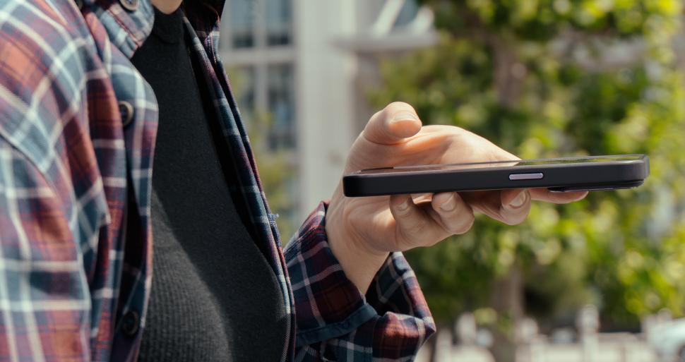 Free Image of Young woman holding a smartphone for voice recording or navigation  