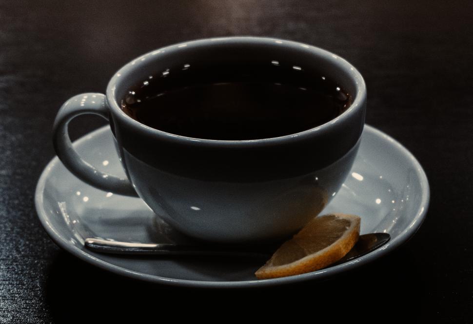 Free Image of A cup of black tea with lemon on a dark table  
