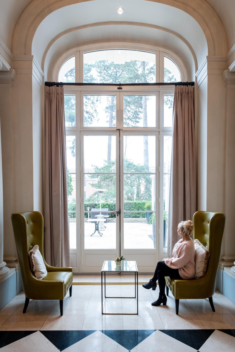 Free Image of Elegant interior with a woman relaxing in a stylish lounge area 