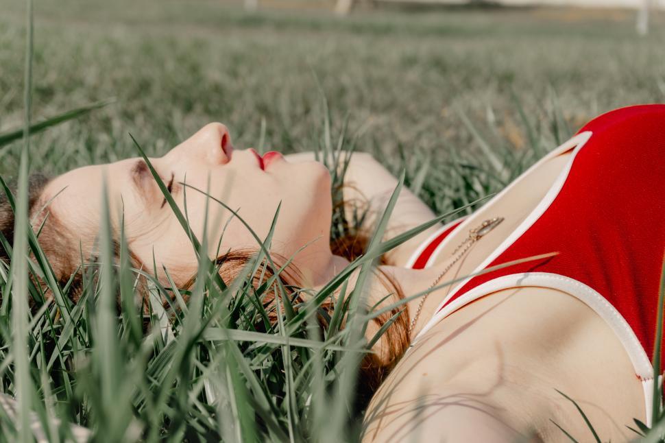 Free Image of Young woman lying on green grass  