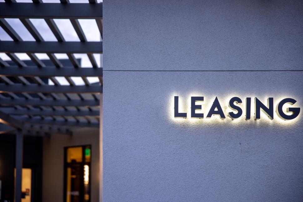 Free Image of Leasing office sign illuminated at dusk in commercial area 