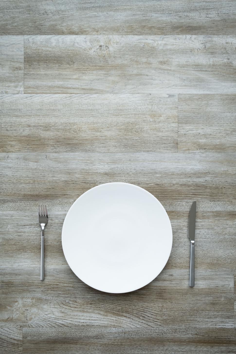 Free Image of Set dining table with empty white plate and utensils arranged neatly 