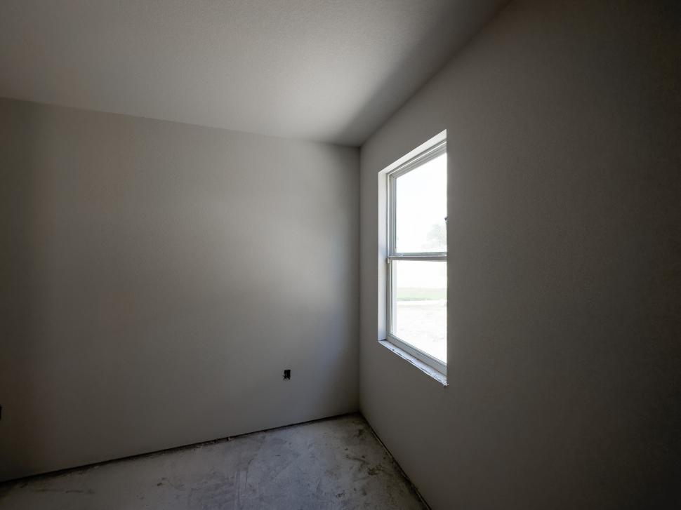 Free Image of Bright, empty room with a single window by day 