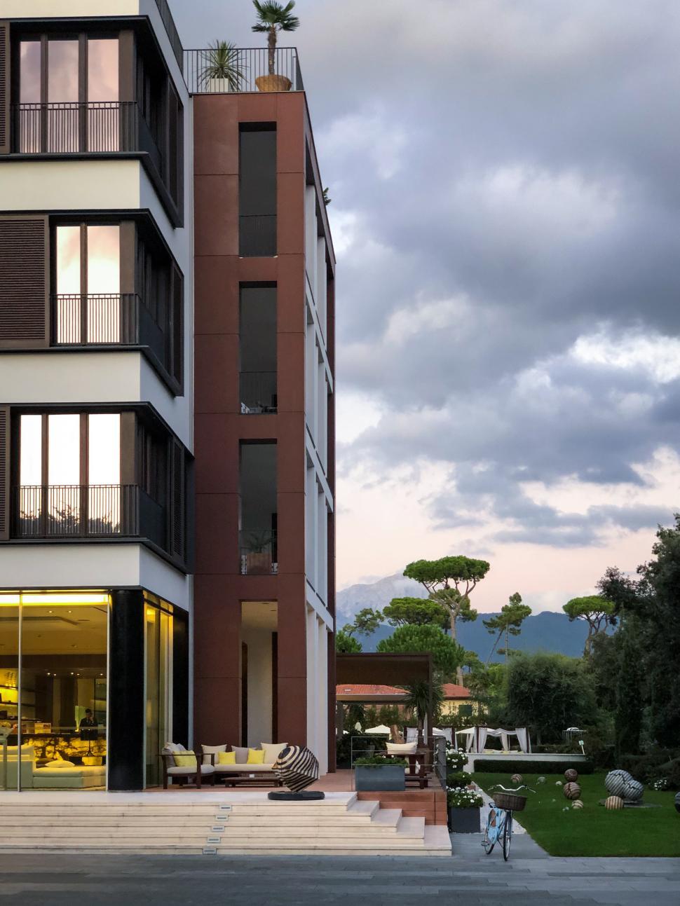 Free Image of Modern building with outdoor seating in serene garden setting 