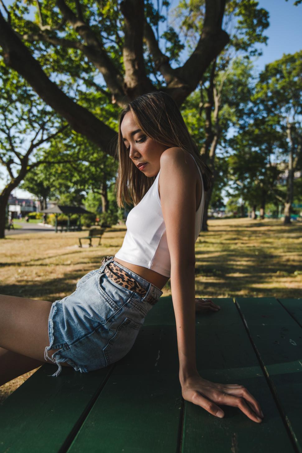Free Image of Woman relaxing in a park during sunny afternoon 