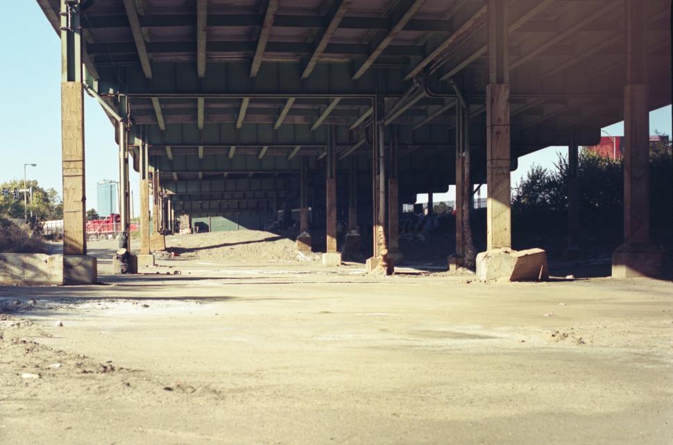 Free Image of Underneath an urban overpass showcasing empty streets and minimal vegetation 