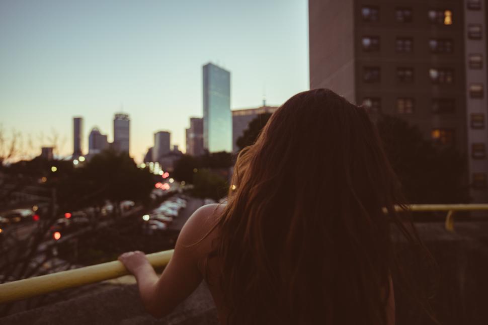 Free Image of City skyline at twilight with a woman enjoying the view 