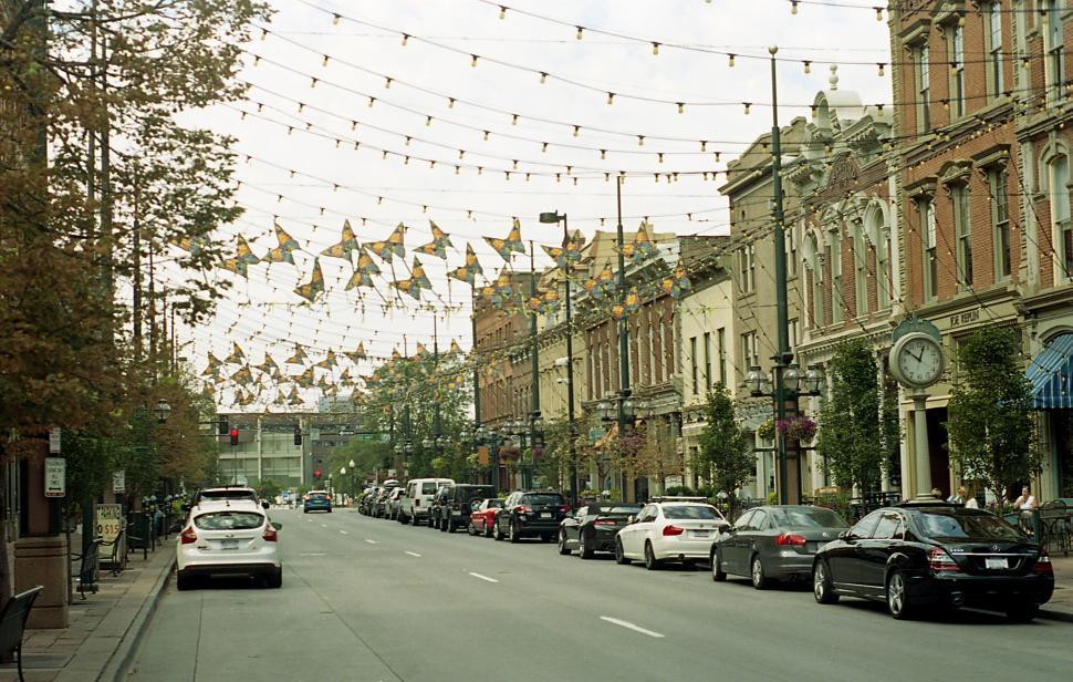 Free Image of Decorative street with festive lights and busy traffic in a charming town 