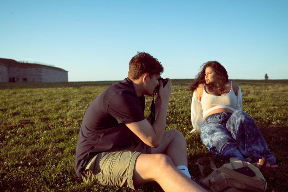 Free Image of Couple enjoys a sunny day while capturing memories outdoors 