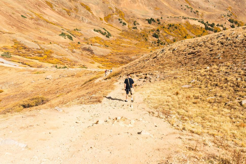 Free Image of Hikers enjoying a scenic trail under clear blue sky 