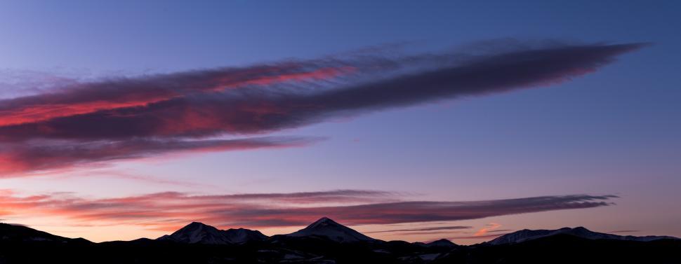 Free Image of Mountain sunset with colorful clouds over peaks in the evening sky 
