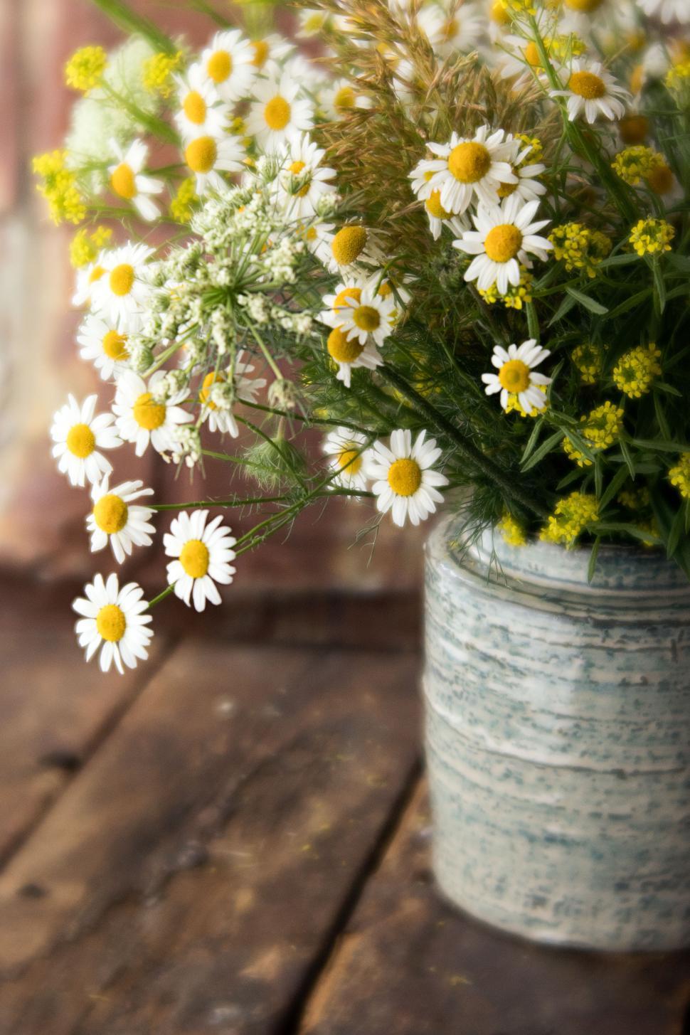 Free Image of Bright floral arrangement in rustic vase on wooden table 