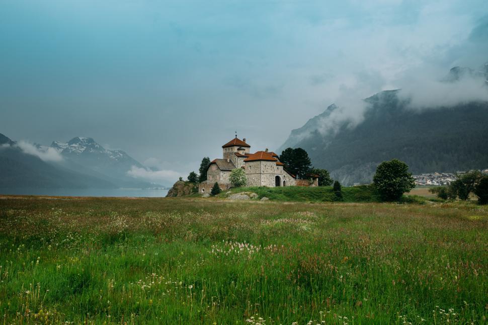 Free Image of Scenic monastery surrounded by mountains and greenery 