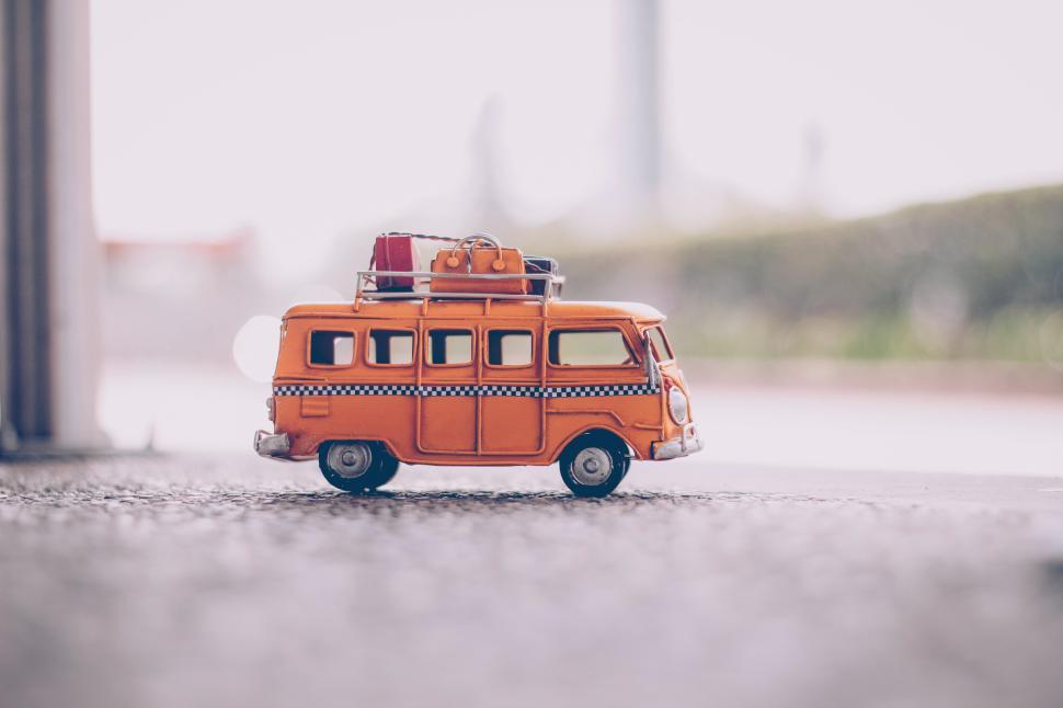 Free Image of Orange toy van with luggage parked at a roadside during daytime 