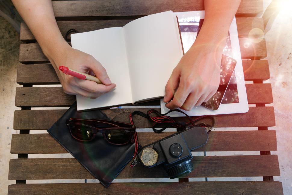 Free Image of Creative writing session with notebook and camera on wooden table 