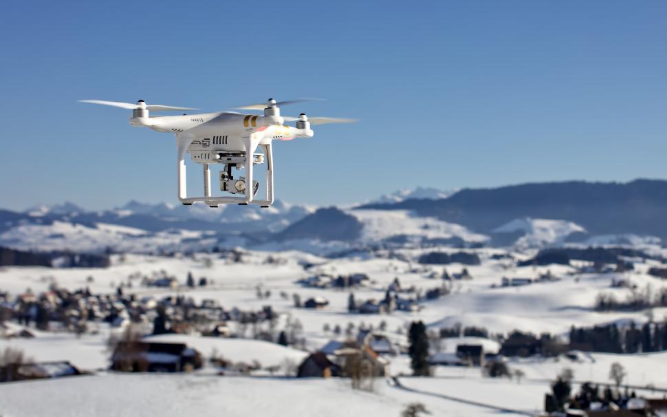 Free Image of Drone flying over snowy landscape in winter daylight 