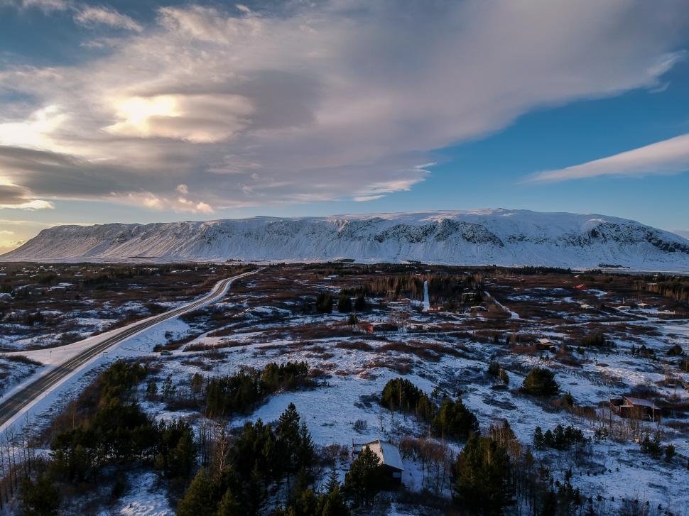 Free Image of Stunning winter landscape in Iceland with snow-covered mountains and winding road 