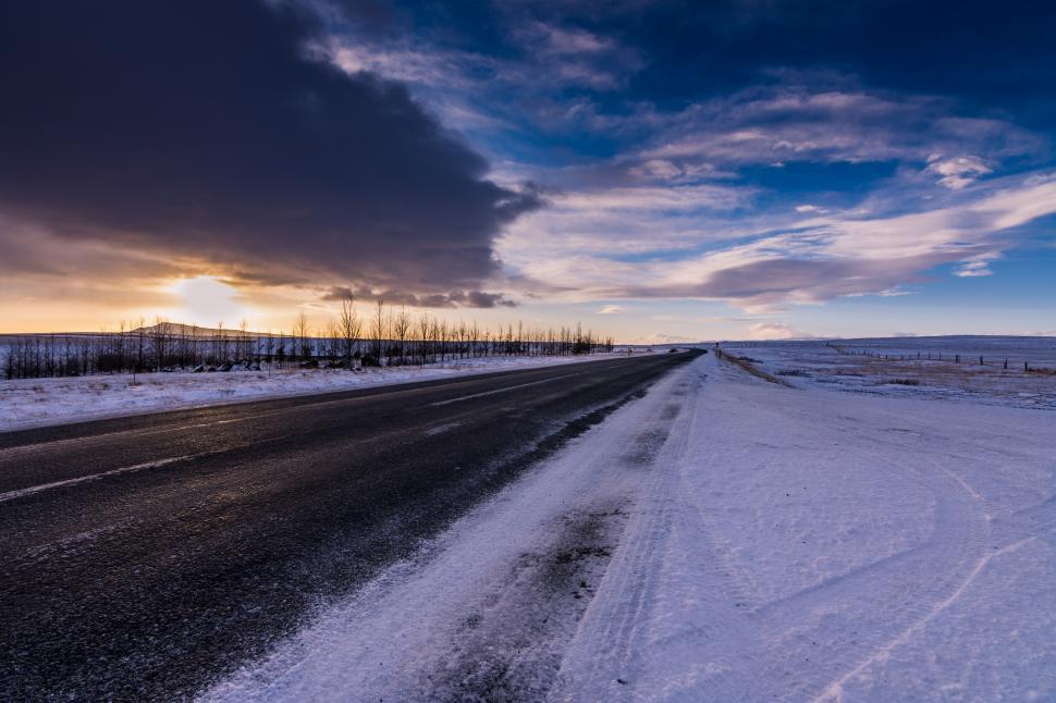 Free Image of Winter sunset over a snow-covered road in a remote landscape 