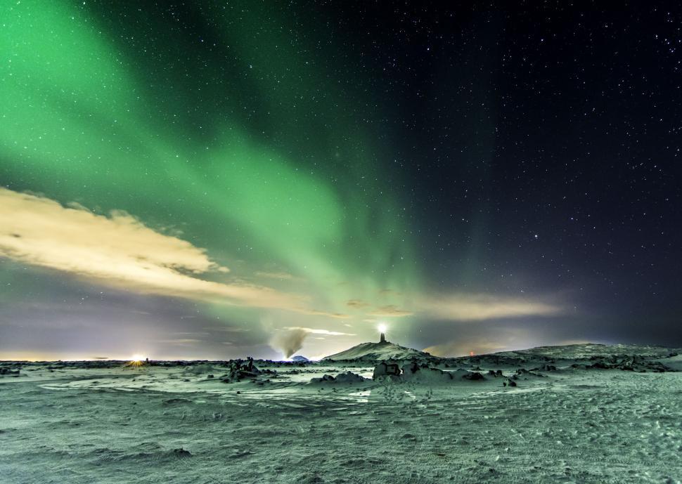 Free Image of Dazzling northern lights illuminate a serene landscape at night 