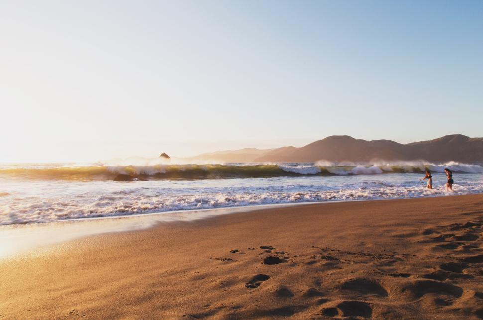 Free Image of Sunset surf session at the beach with waves crashing 