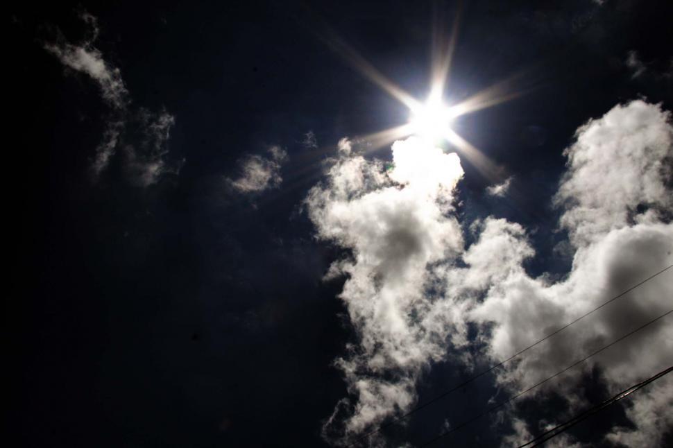 Free Image of Sun peeking through clouds 