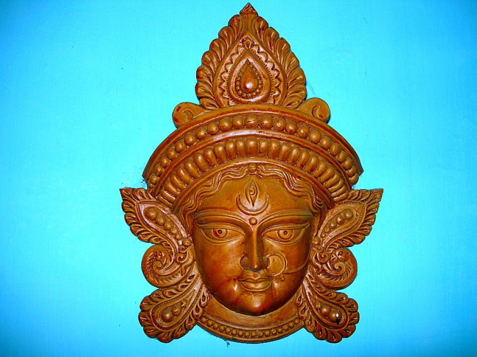 Free Image of Wooden Carving of Face on Blue Background 
