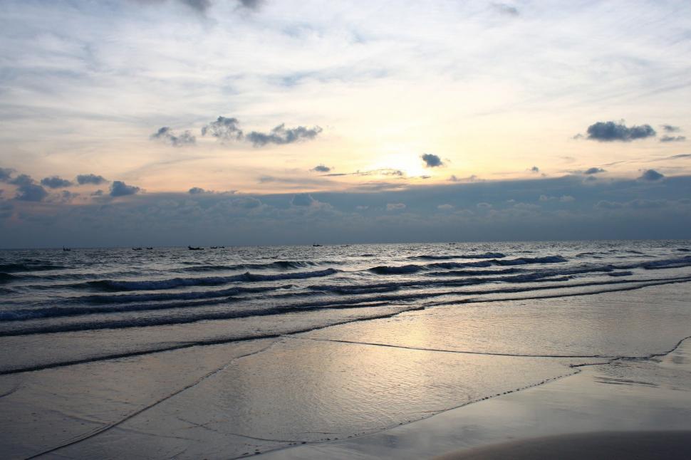 Free Image of Sun Setting Over Water at Beach 