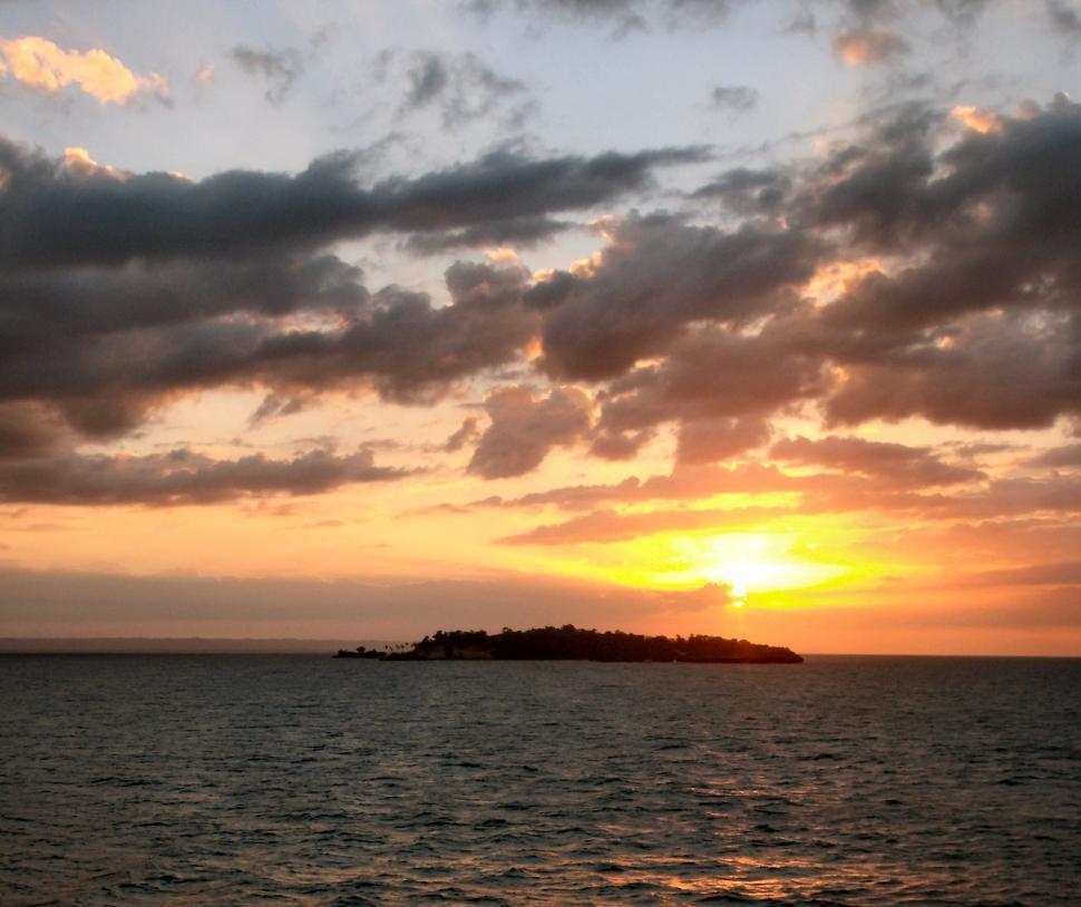 Free Image of Beautiful colorful sunset over the ocean with clouds and small island 