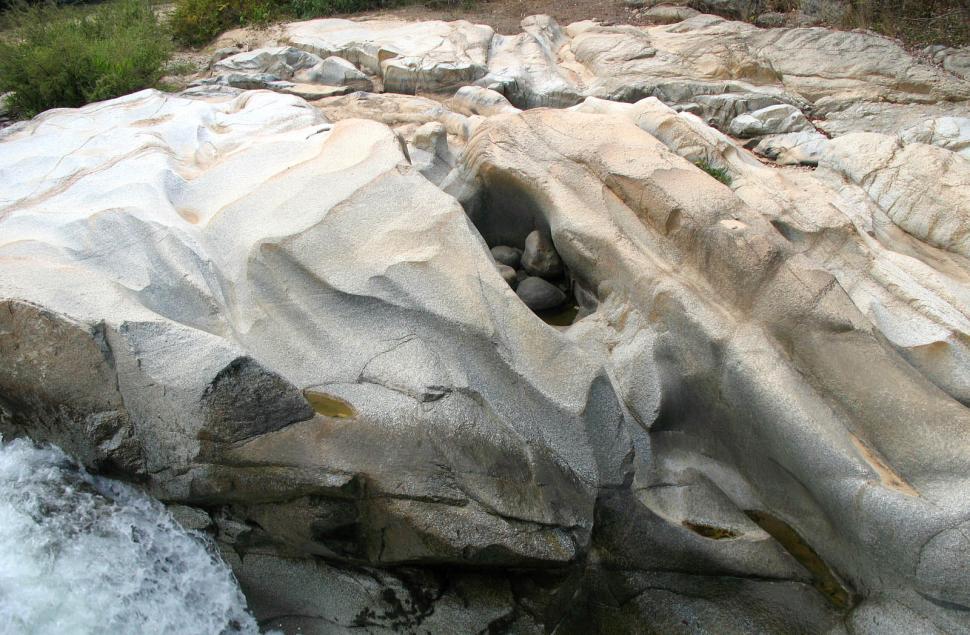 Free Image of Man Standing on Rock by River 