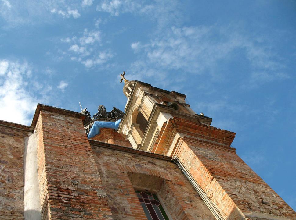 Free Image of Tall Brick Building With Statue on Top 