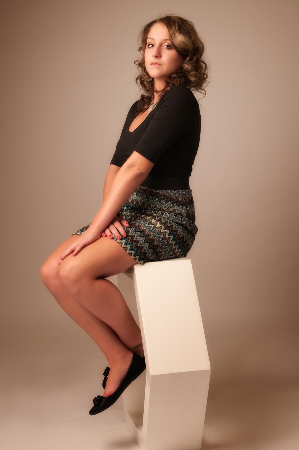 Free Image of Woman sits on white hexagon 