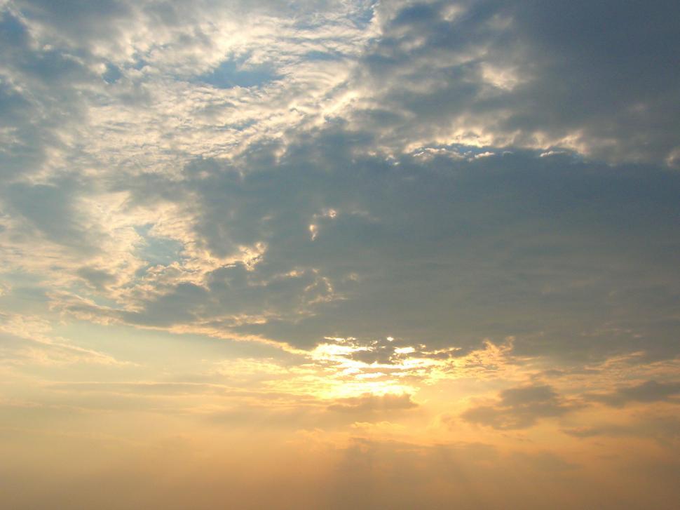 Free Image of Sun Shining Through Clouds Over Ocean 