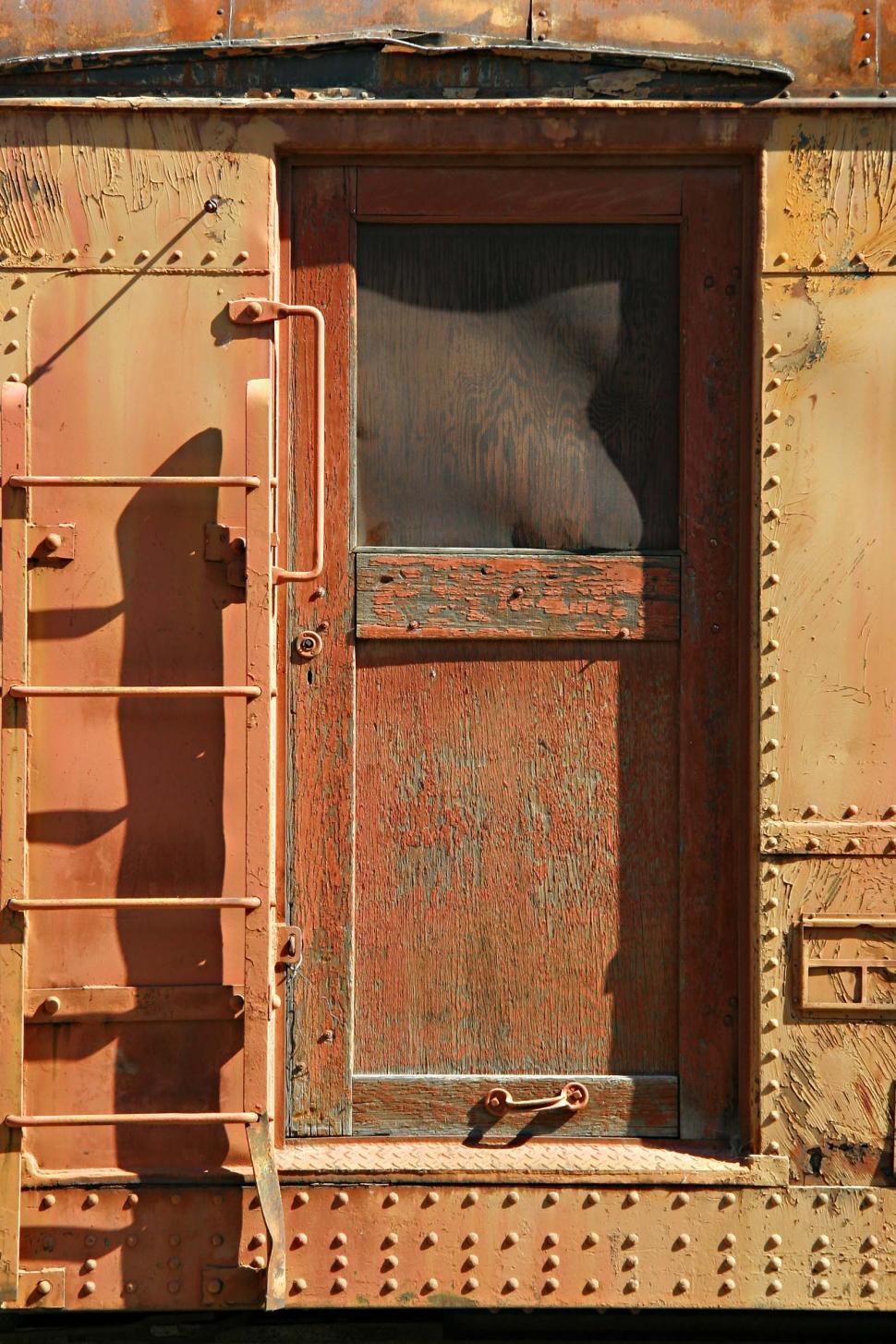 Free Image of Persons Shadow Cast on Side of Train Car 