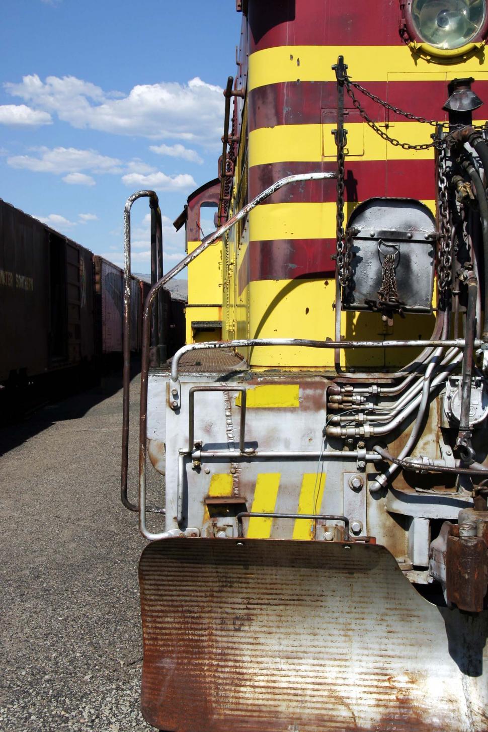 Free Image of Red and Yellow Train Traveling Down Train Tracks 